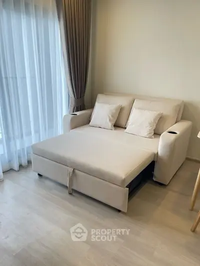 Modern living room with beige sofa bed and sheer curtains