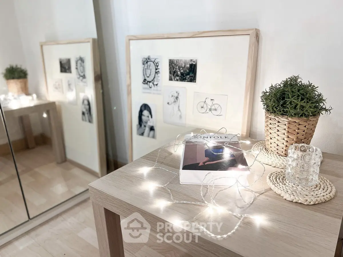 Stylish interior decor with framed art, potted plant, and magazine on wooden table.