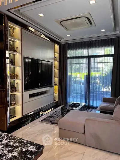 Luxurious living room with modern decor and large TV, featuring elegant marble flooring and stylish furniture.
