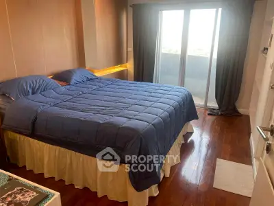 Cozy bedroom with wooden flooring and balcony access in modern apartment