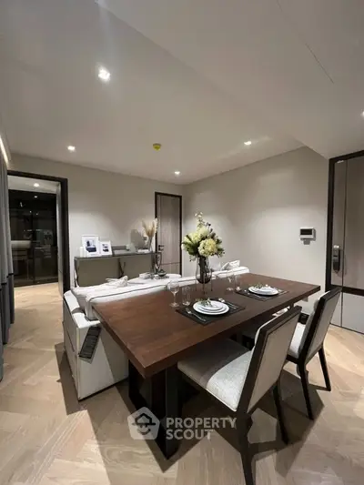 Modern dining area with elegant table and chairs, stylish decor, and ambient lighting in a contemporary apartment.