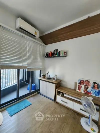 Modern living room with balcony, air conditioning, and stylish decor in a cozy apartment.