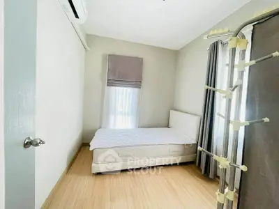 Cozy bedroom with minimalist decor and natural light, featuring a comfortable bed and modern air conditioning.