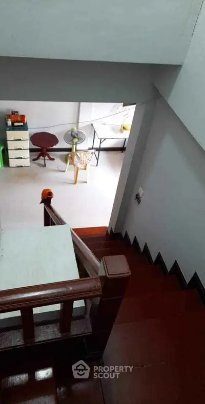 Spacious interior stairway leading to a bright, well-lit room with modern furniture.