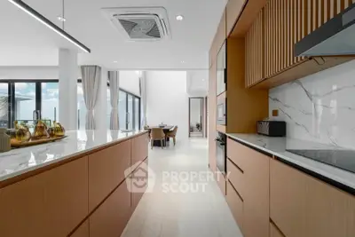 Luxurious modern kitchen with sleek design and open layout, featuring marble countertops and high-end appliances.