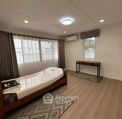 Spacious bedroom with modern decor and large windows for natural light