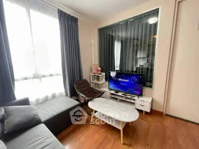 Modern living room with cozy seating and large window, perfect for relaxation.