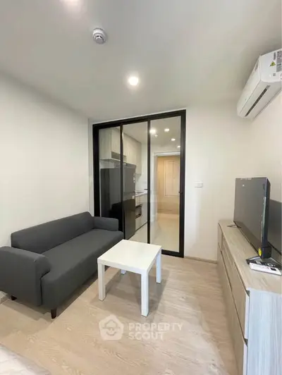 Modern living room with sleek furniture and glass partition in a stylish apartment.