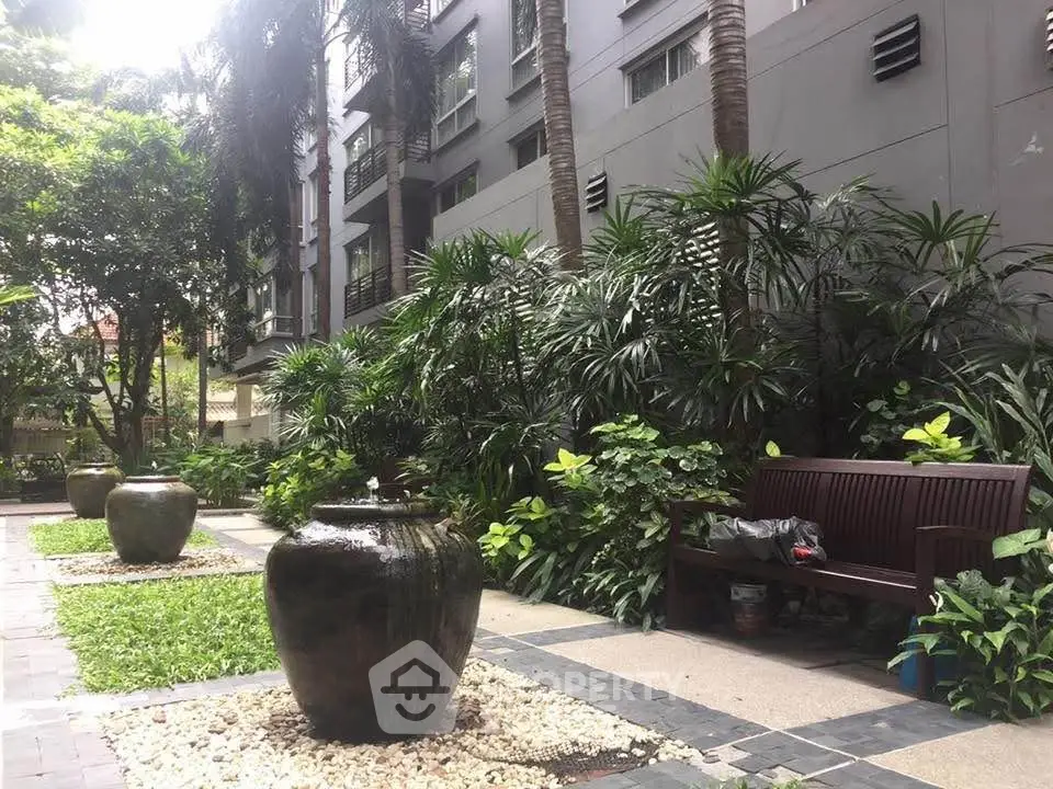 Lush garden area with modern planters and seating in a residential complex.