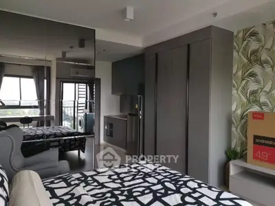 Modern bedroom with stylish decor and integrated kitchen area, featuring large windows and sleek furniture.