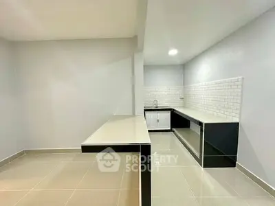 Modern kitchen with sleek black cabinets and white subway tiles