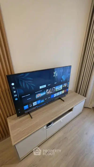Modern living room with sleek TV setup on stylish wooden console, perfect for entertainment.
