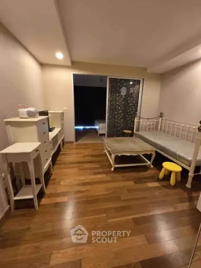 Charming bedroom with wooden flooring and elegant furniture, perfect for cozy living.