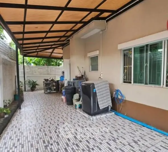 Spacious covered outdoor area with tiled flooring and storage space.