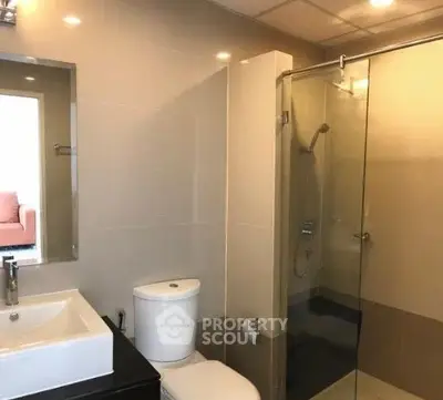 Modern bathroom with glass shower and sleek fixtures in a contemporary home.
