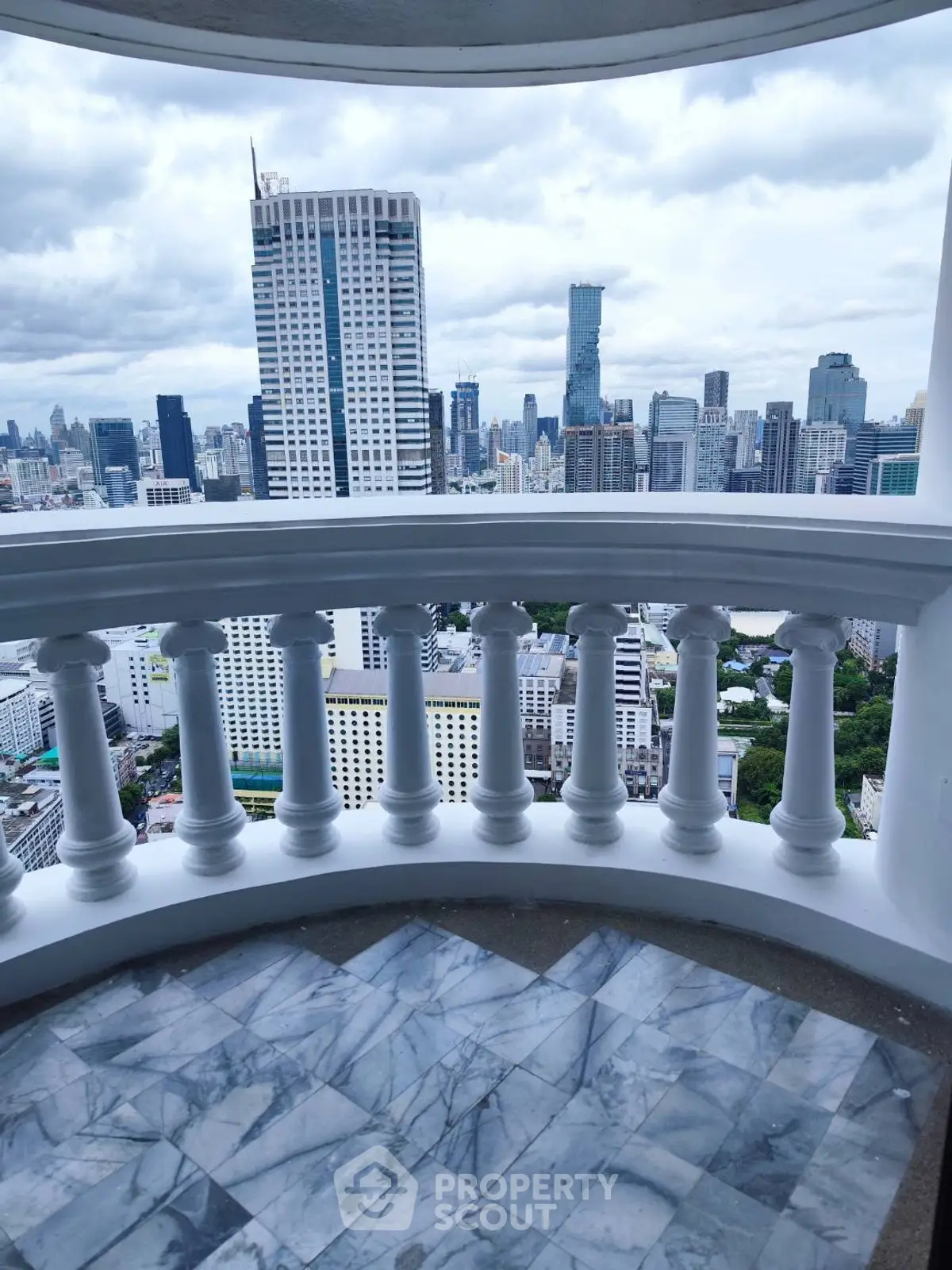 Stunning cityscape view from a high-rise balcony with elegant balustrade.