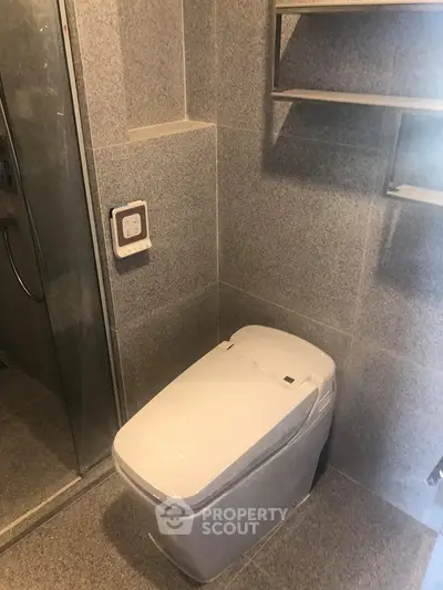 Modern bathroom with sleek toilet and glass shower enclosure