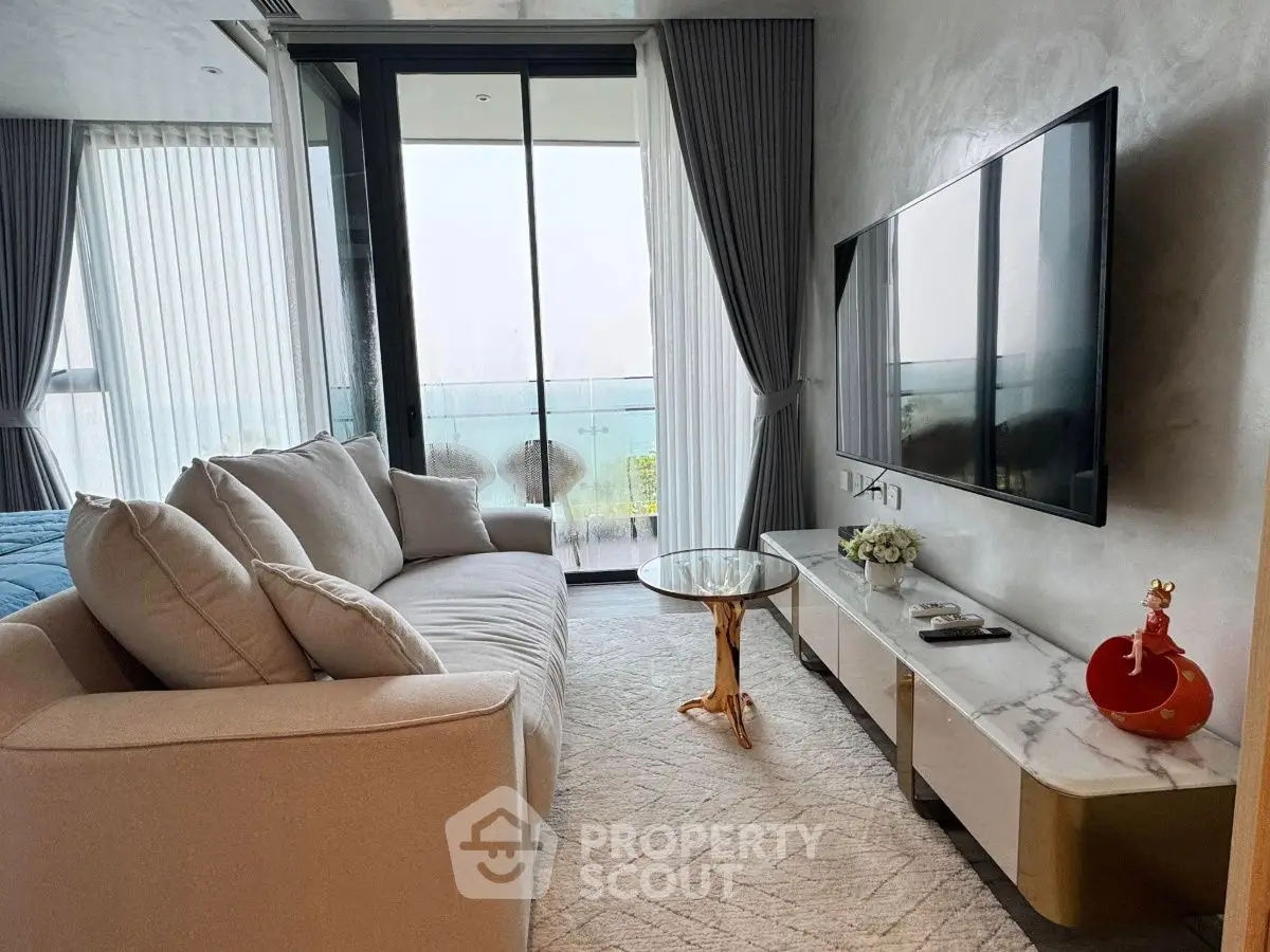 Luxurious living room with modern decor and stunning ocean view balcony.