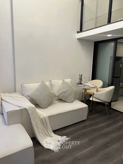 Modern living room with elegant decor and open layout, featuring stylish furniture and sleek flooring.