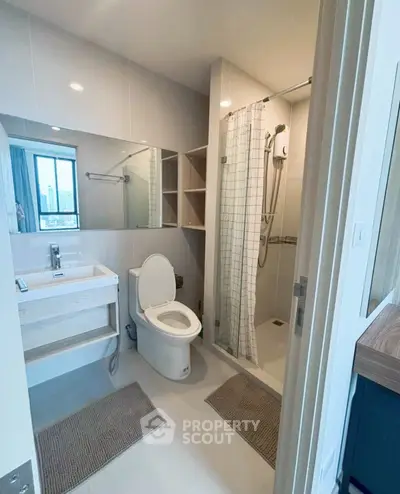 Modern bathroom with shower and city view window in stylish apartment.
