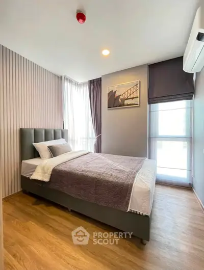 Modern bedroom with stylish decor and natural light in a contemporary apartment.