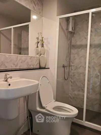 Modern bathroom with sleek shower and elegant sink in stylish apartment.