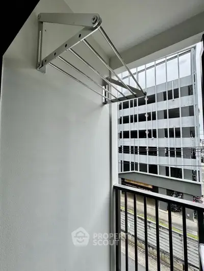 Modern balcony with sleek metal drying rack and urban view