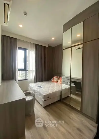 Modern bedroom with sleek design, large mirrored wardrobe, and ample natural light.