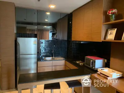 Modern kitchen with stainless steel appliances, sleek cabinetry, and a convenient breakfast bar in a stylish urban apartment.