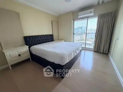 Spacious bedroom with large window and city view, featuring a modern bed and elegant decor.