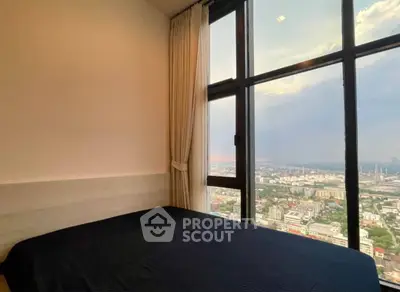 Stunning bedroom with panoramic city view from floor-to-ceiling windows.