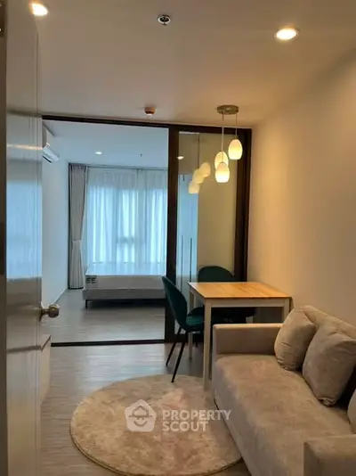 Modern living room with cozy sofa and dining area, leading to a bright bedroom.