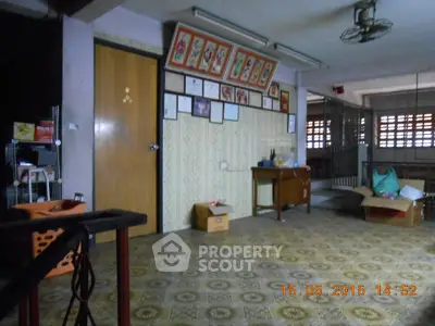 Spacious interior room with vintage decor and patterned flooring, ideal for creative renovation.