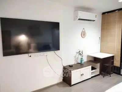 Modern living room with wall-mounted TV and air conditioning unit, featuring sleek furniture and minimalist decor.