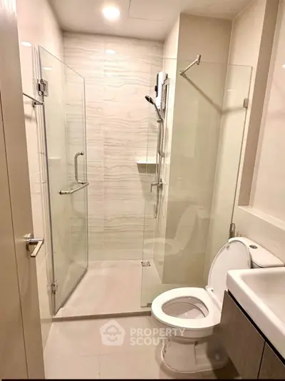 Modern bathroom with glass shower enclosure and sleek fixtures