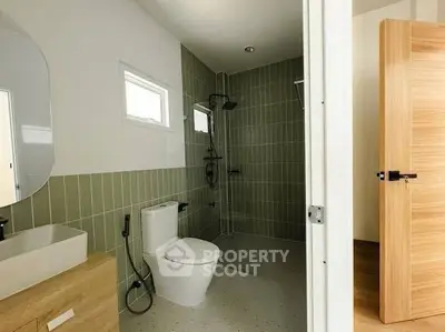 Modern bathroom with sleek fixtures and stylish green tiles