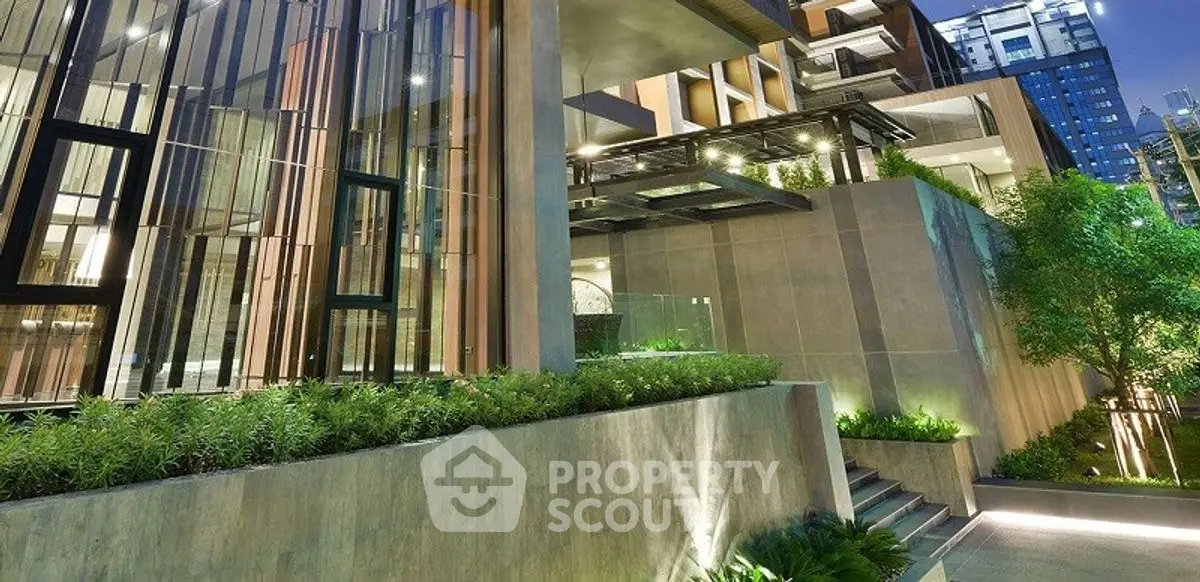 Luxurious modern building exterior with lush greenery and sleek architectural design.