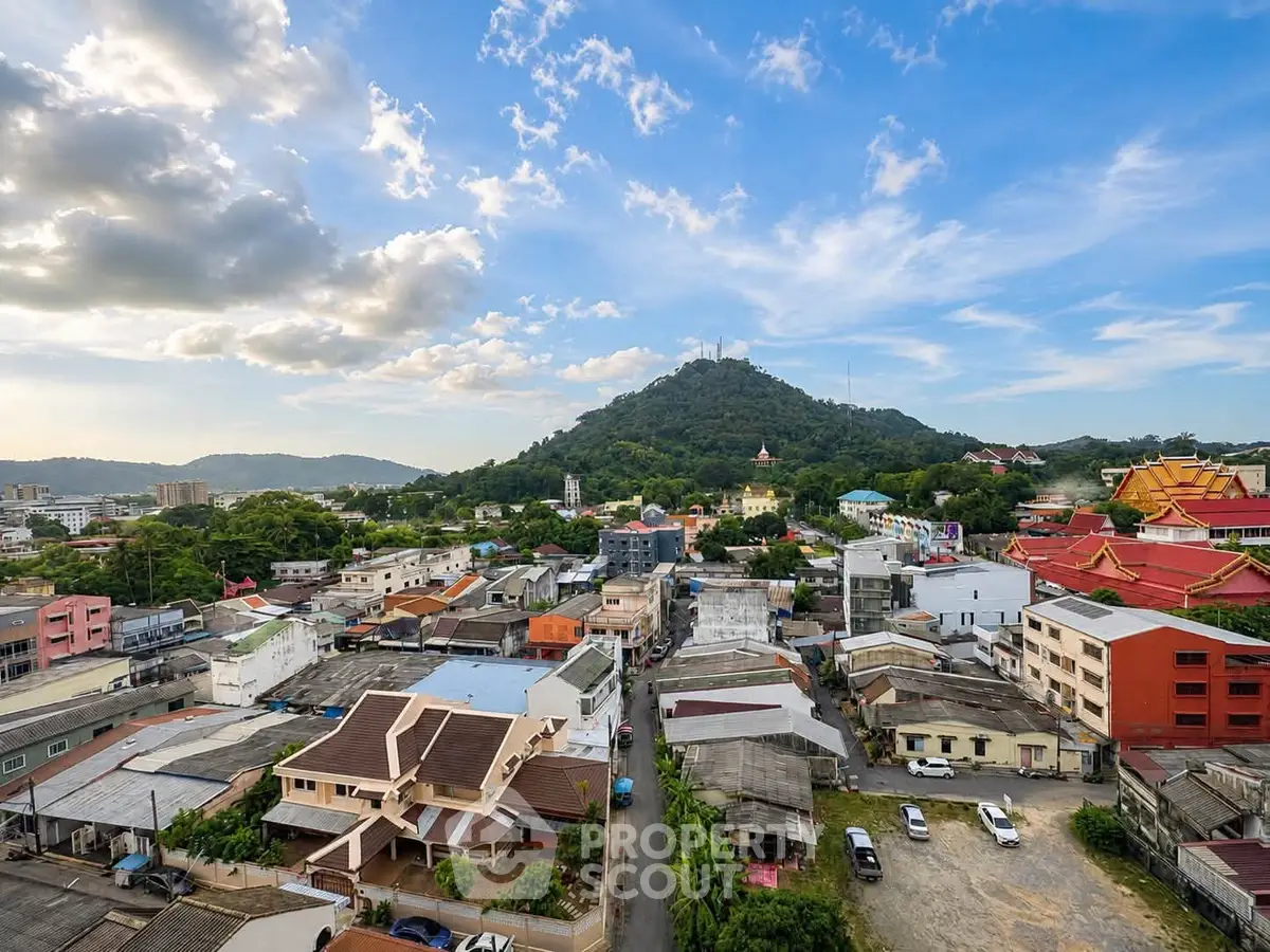 Stunning aerial view of a vibrant cityscape with lush green hills and blue sky, perfect for urban living.