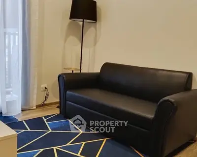 Modern living room with sleek black sofa and stylish geometric rug