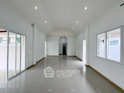 Spacious modern living room with high ceilings and large windows for natural light.