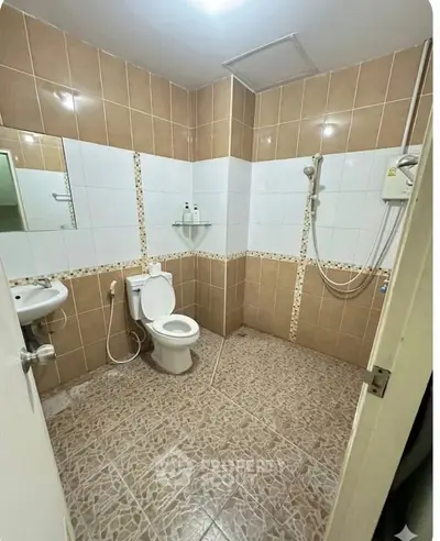 Spacious bathroom with modern fixtures and tiled walls in a real estate property.