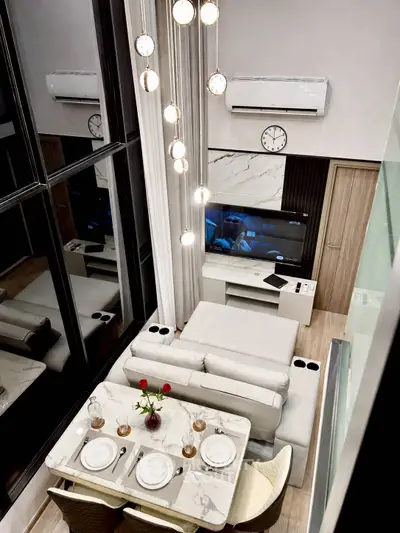 Luxurious modern living room with high ceilings, elegant lighting, and stylish decor for sophisticated living.