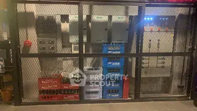 Secure storage area with electrical panels and beverage crates, ideal for utility management in commercial properties.