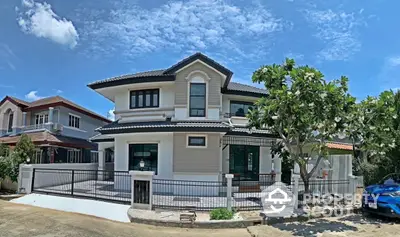 Stunning two-story house with modern architecture and lush greenery in a serene neighborhood.