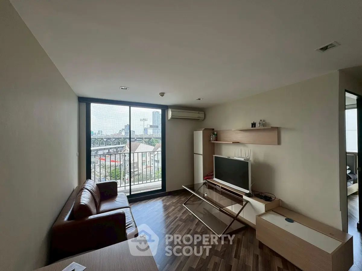 Modern living room with city view, featuring sleek furniture and large windows for natural light.