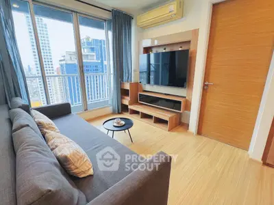 Modern living room with city view, stylish furniture, and large TV setup.