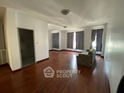 Spacious living room with hardwood floors and natural light
