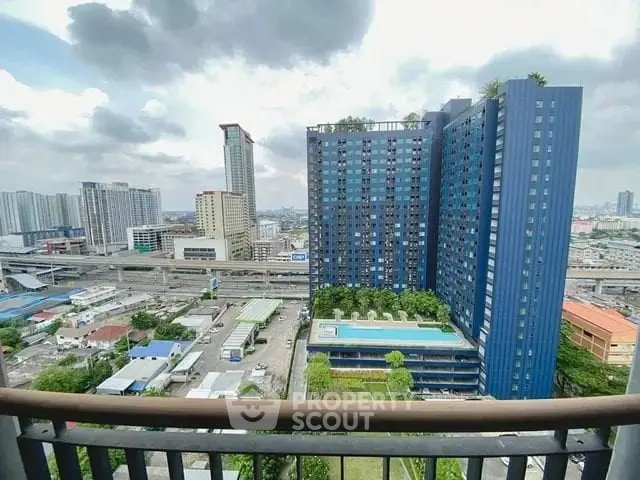 Stunning cityscape view from high-rise balcony overlooking modern buildings and urban skyline.
