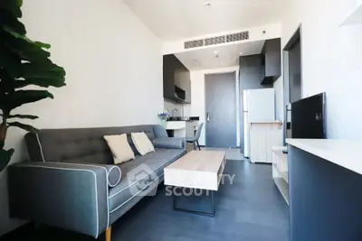 Modern living room with sleek furniture and open kitchen layout in a stylish apartment.