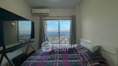 Cozy bedroom with large window offering stunning city view and modern TV setup.